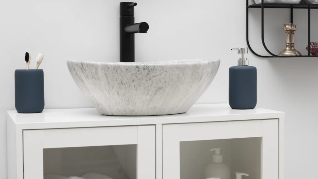 Gray marble-patterned vessel sink sitting on top of a white bathroom vanity with a tall black faucet