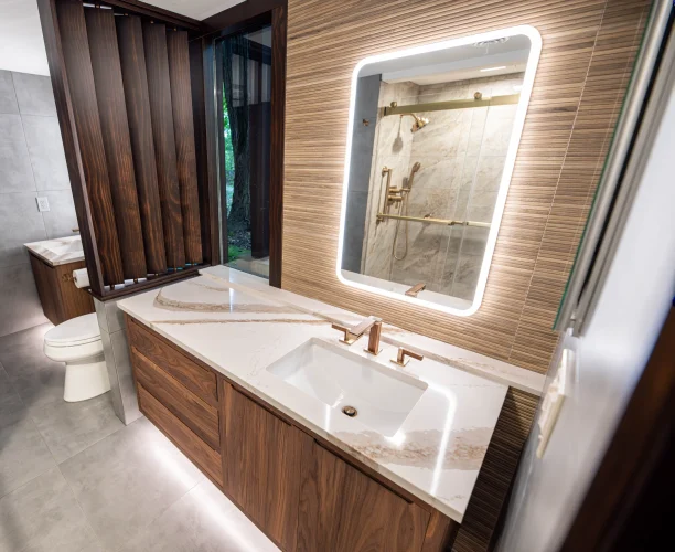 Floating wood-grain vanity with a veined countertop, rectangular sink and illuminated mirror